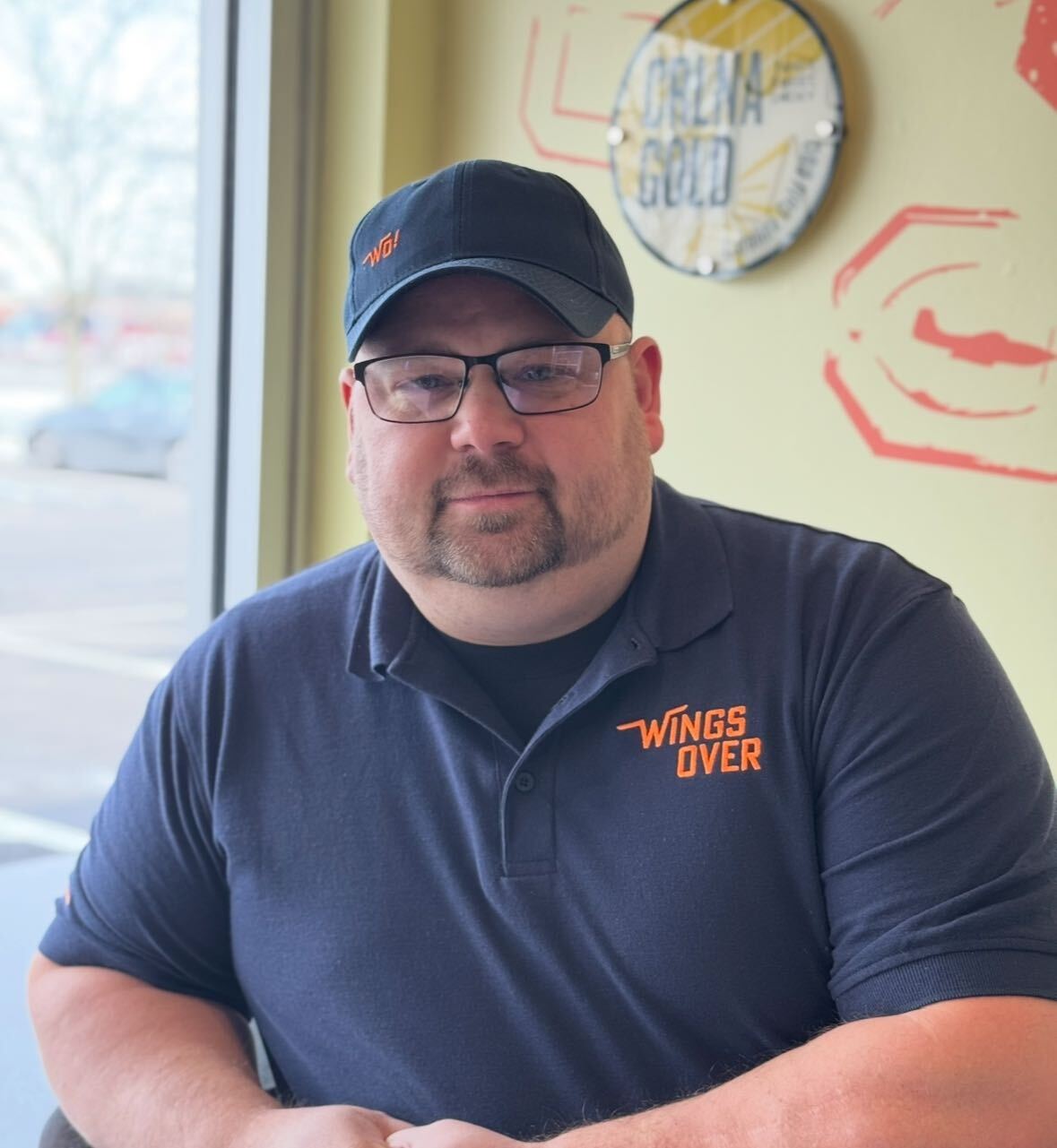Mitch proudly smiling, reflecting on his experience at Wings Over, the best wing place for crispy chicken wings and tenders.