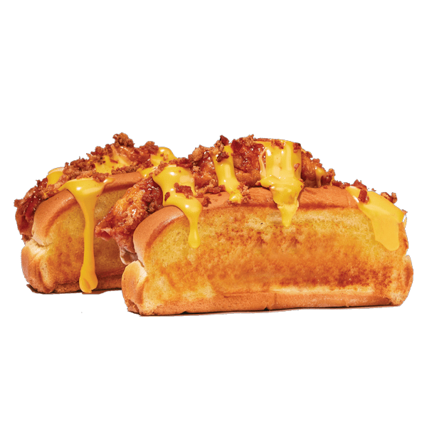 Toasted buns with fried chicken, cheese sauce, and bacon bits, served on a white surface