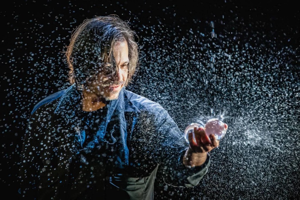 Top 5 de Trucos de Magia Especializados en 2025 14 Mago moderno realizando un truco con agua, creando un efecto visual impresionante presentes en cada Trucos de Magia para principiantes y magos profesionales.
