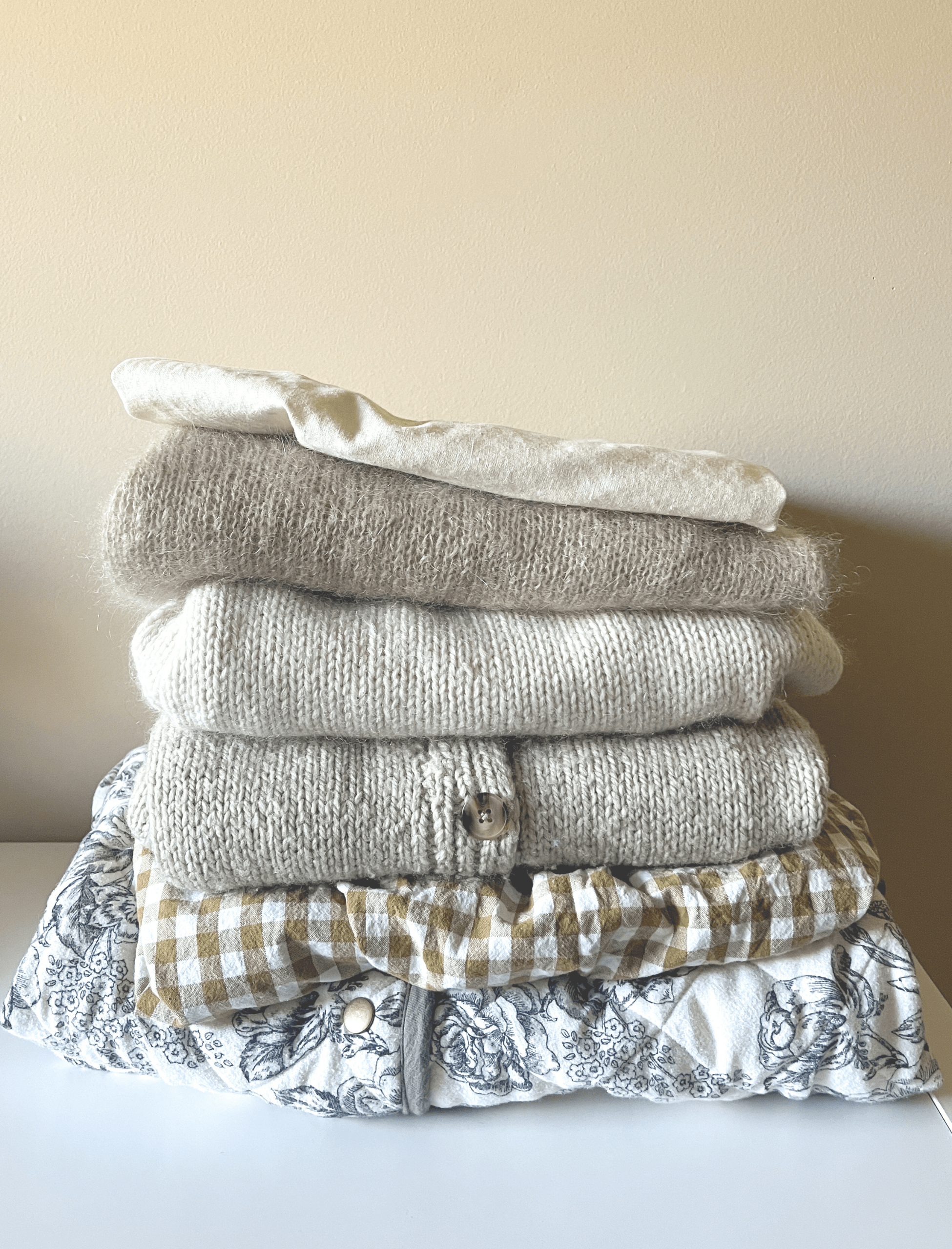 A stack of hand made clothes in natural materials.