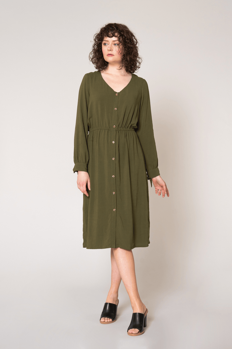 a woman wearing a green botton up dress sewing pattern