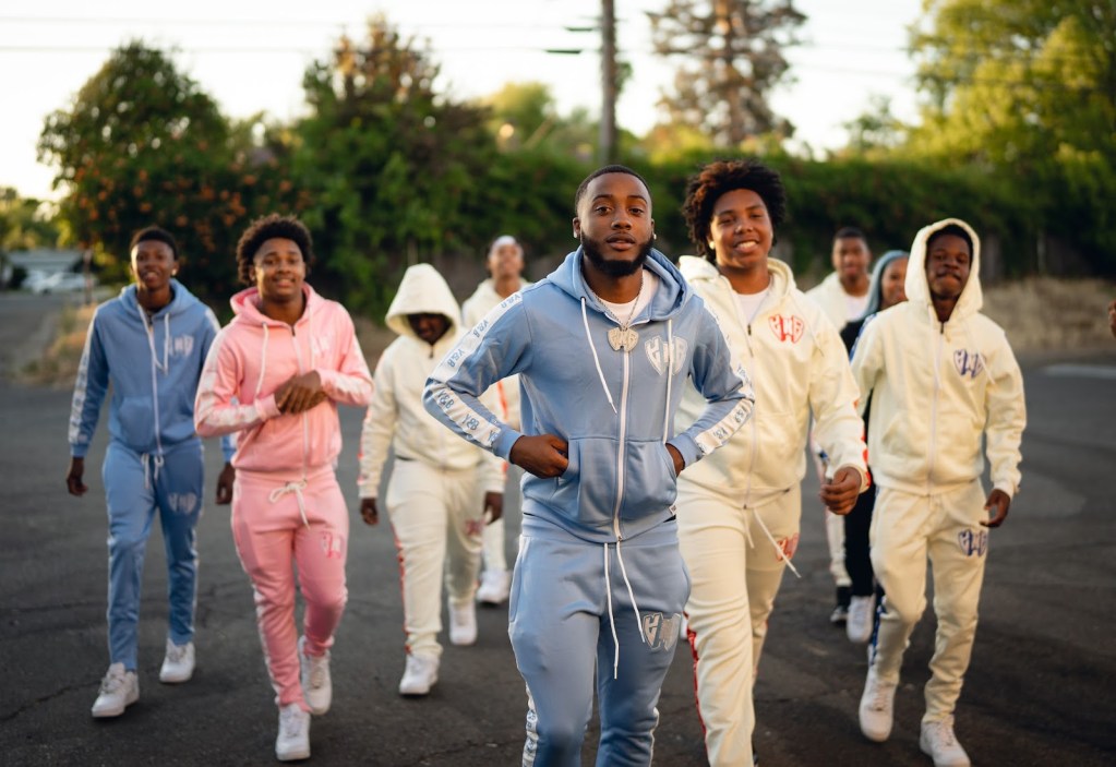 A group of Black people walk together in matching sweatsuits