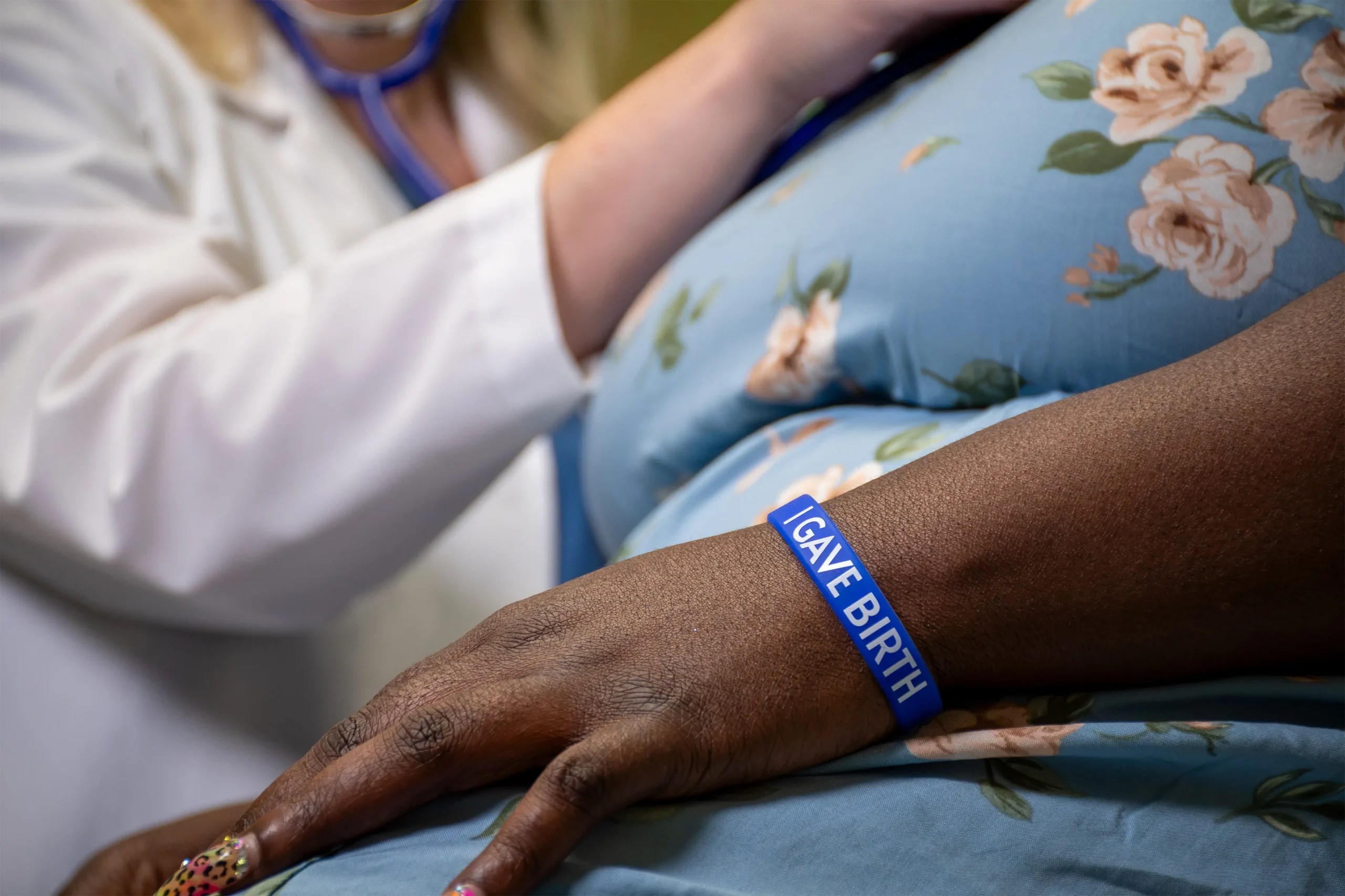 Hospitals are embracing a low-cost tool designed to protect women after childbirth. But experts say its expansion comes as Medicaid cuts could undermine the healthcare system postpartum patients need when that wristband tells them something is wrong.
