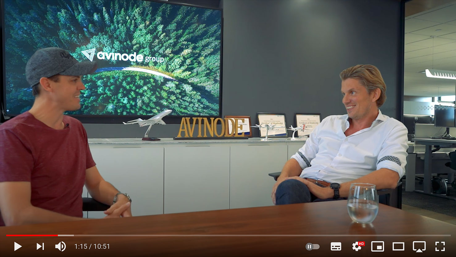 A screen shot of a youtube video with two men sitting in a conference room talking.