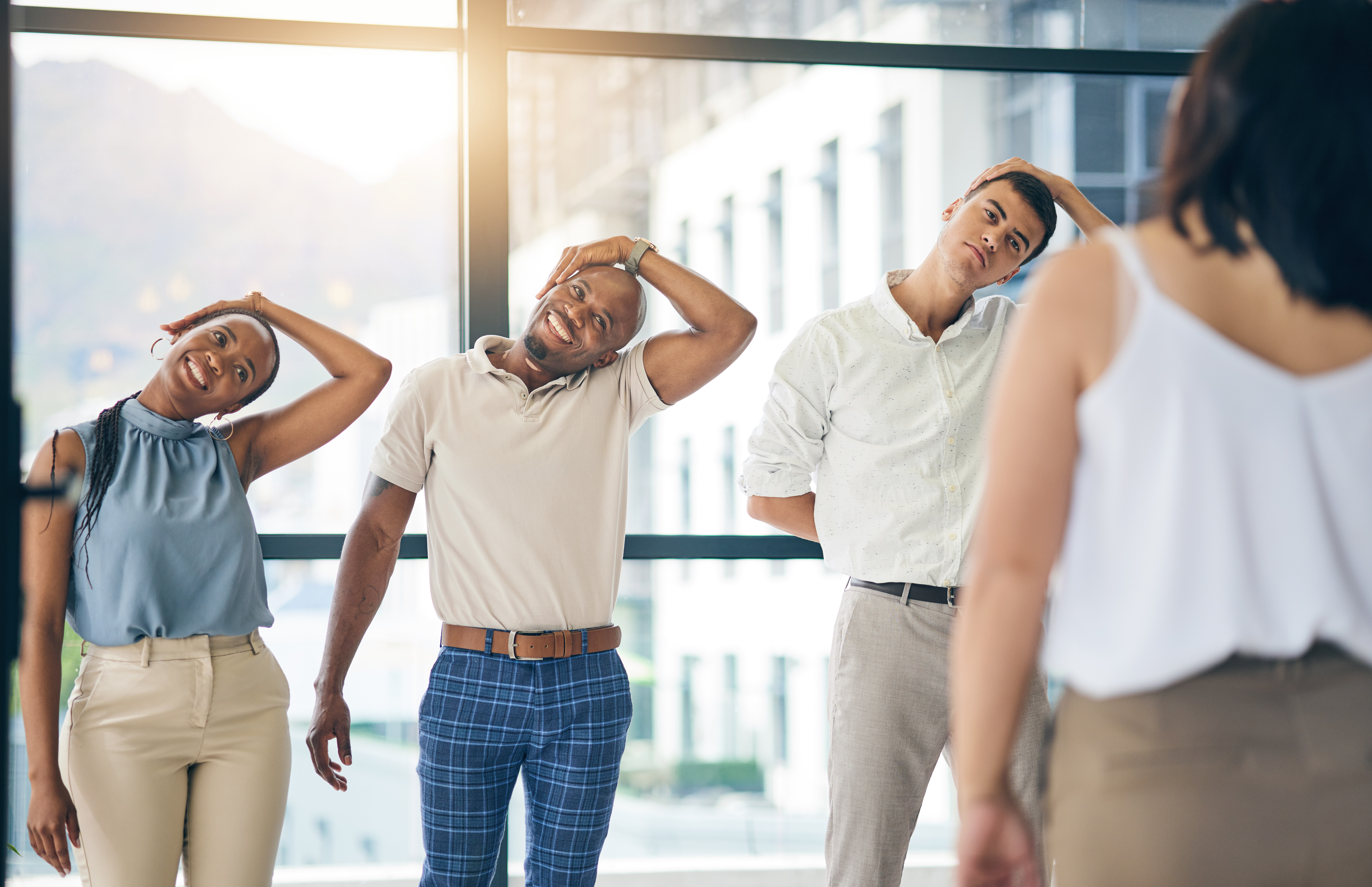 Skipping warm up? This is why you should not. Three reasons why you should never skip warm up and cool down. Exercise, stretching and a group of business people in the office to workout for health or mobility together. Fitness, wellness and training with an employee team in the workplace for a warm up.
