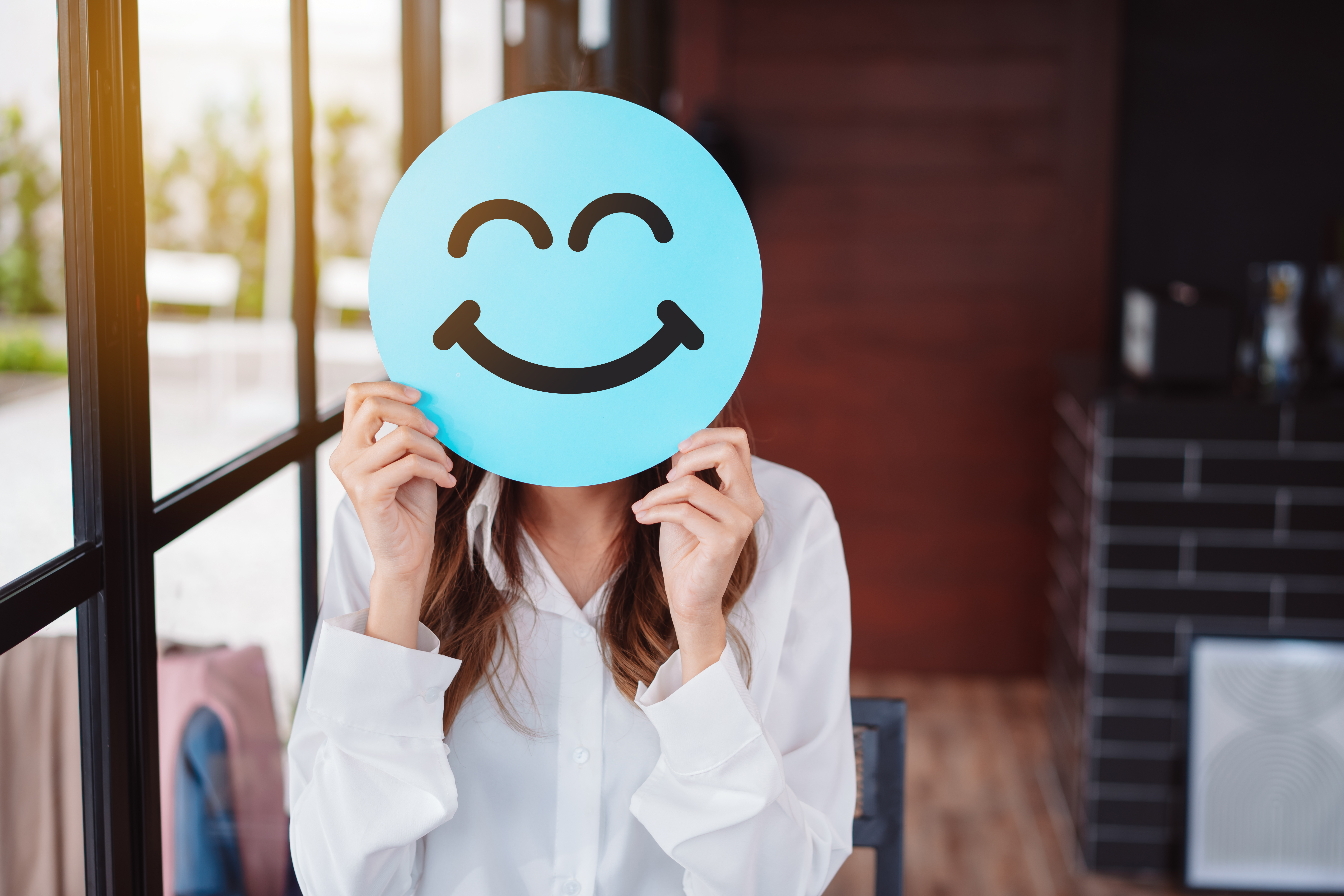 Asian woman holding blue happy smile face on paper cut, user giving good feedback rating, think positive , customer review, assessment, of mental health day, Compliment Day, satisfaction concept. 5 Nutrition Myths That Are Sabotaging Your Health