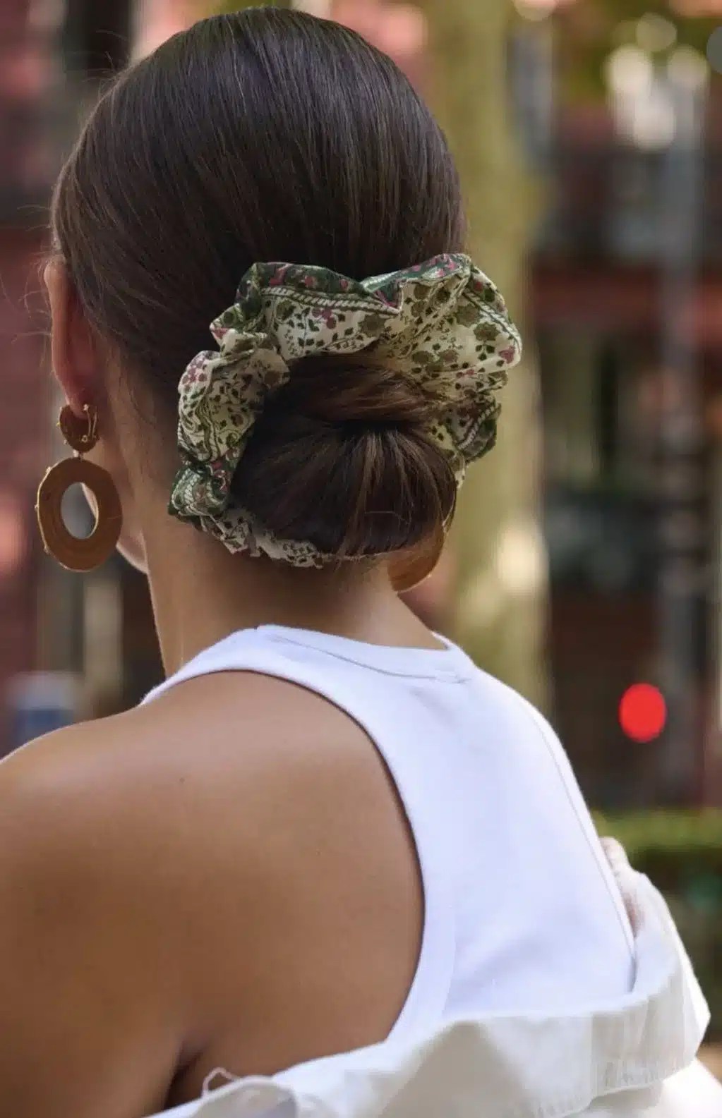 Pool hairstyle featuring a neat bun secured with a silk scrunchie to help minimise breakage while creating an effortless summer hairstyle.