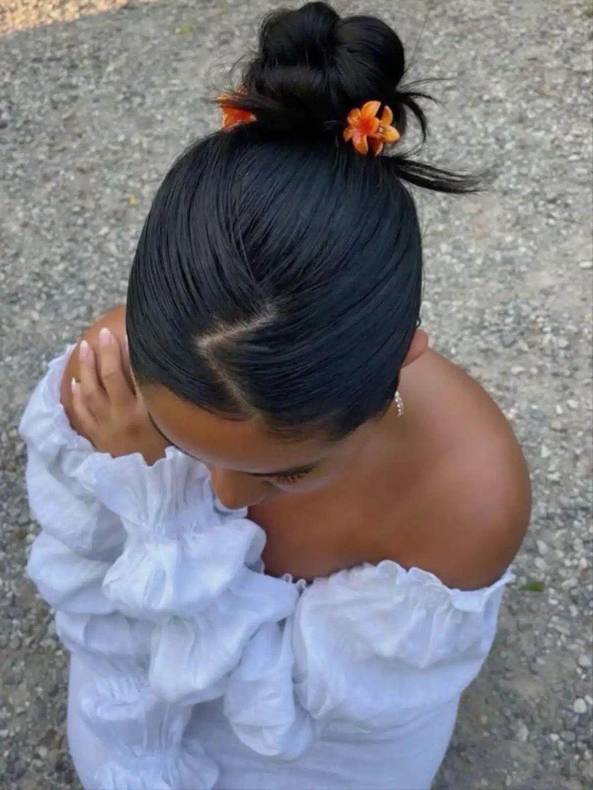 High bun hairstyle decorated with floral hair accessories for an elegant summer updo that's perfect for pool days, beach holidays, and outdoor events.