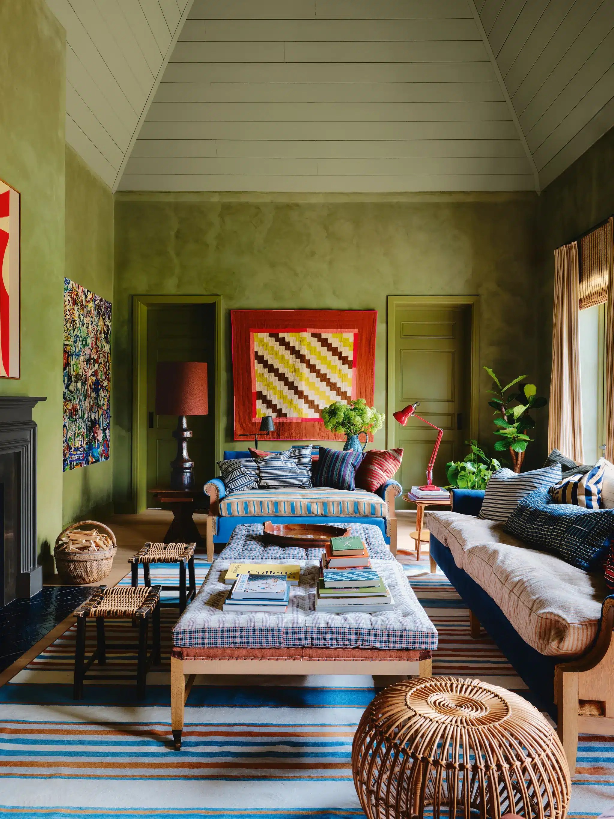 A colorful traditional living room featuring built-in bookshelves, antique furniture, patterned upholstery, framed artwork and collected decorative accessories creating a warm, lived-in interior.