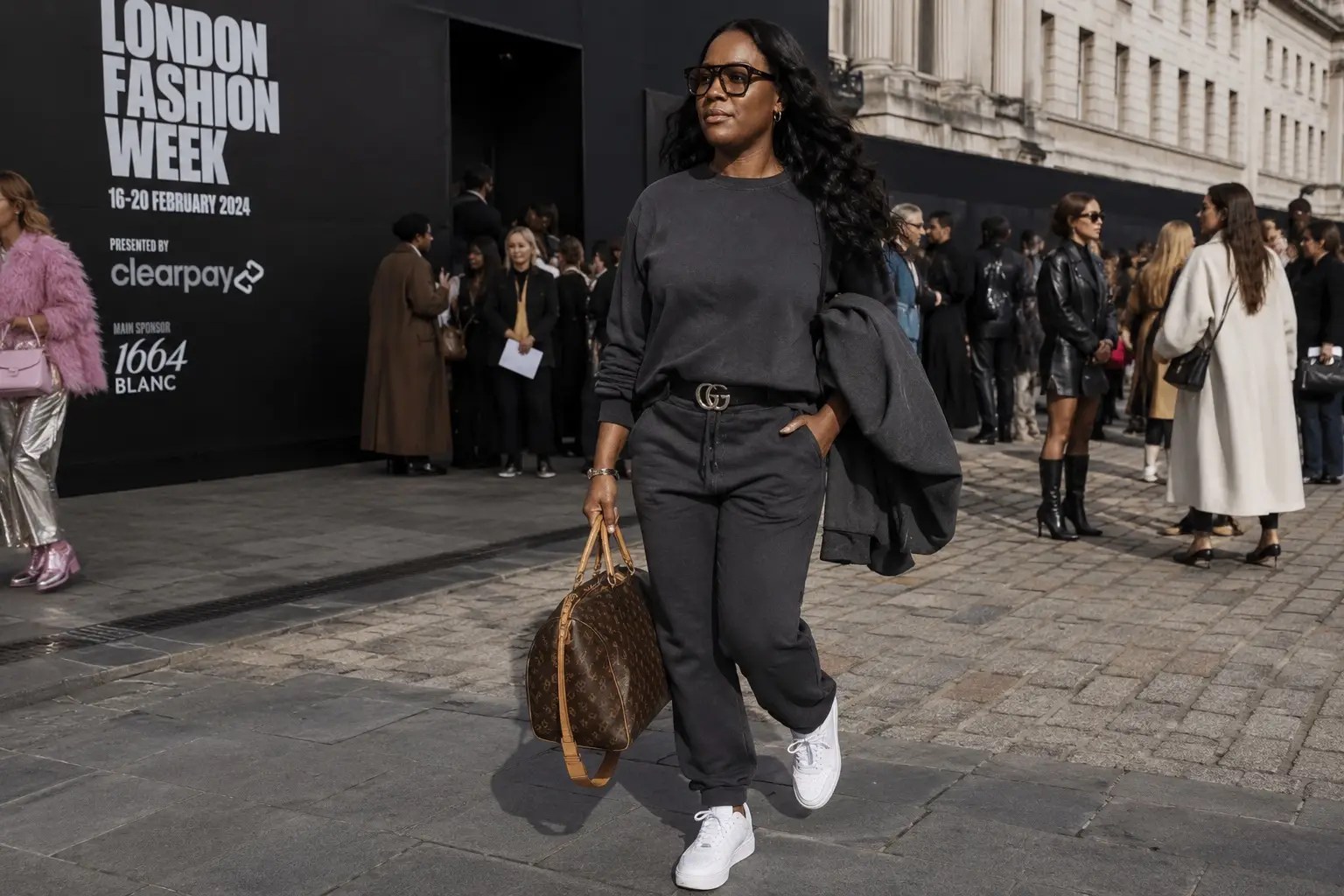 Lee-Anne arriving at London Fashion Week in a charcoal tracksuit, white trainers and Meta glasses, showing that personal style and confidence are about authenticity rather than dressing like everyone else.