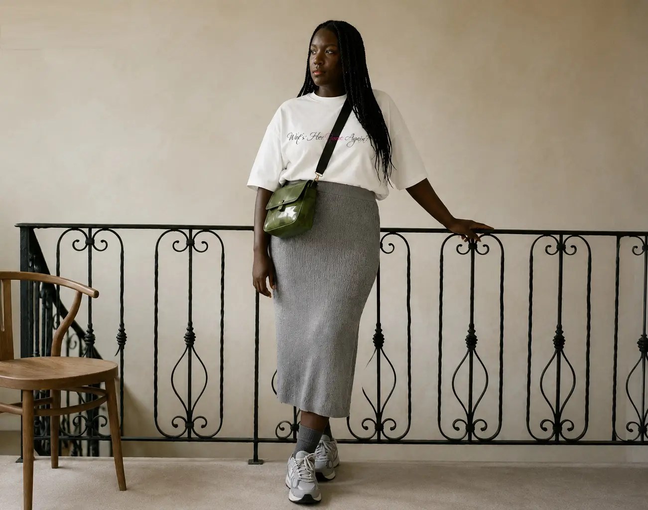 Black woman in a Wot’s Her Name Again? T-shirt and grey skirt, representing Social Life With Lupus, personal style and confident living.