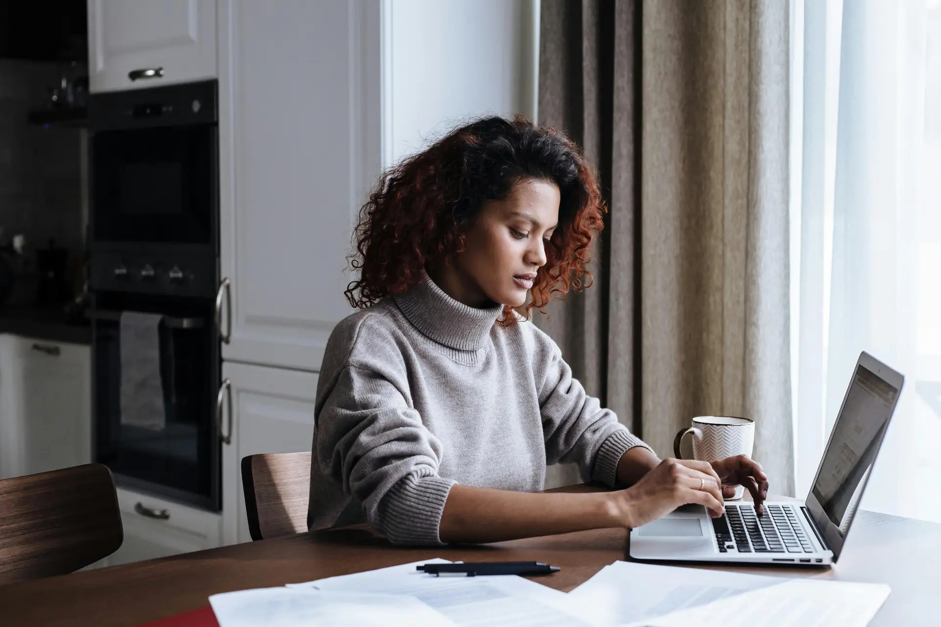 Woman working from home with Lupus researching Working And Personal Independence Payment support on a laptop