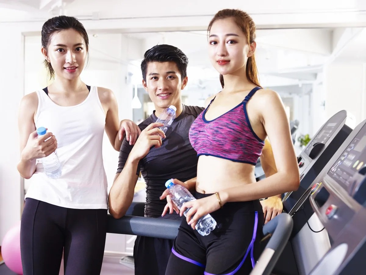 portrait of three young asian people in gym