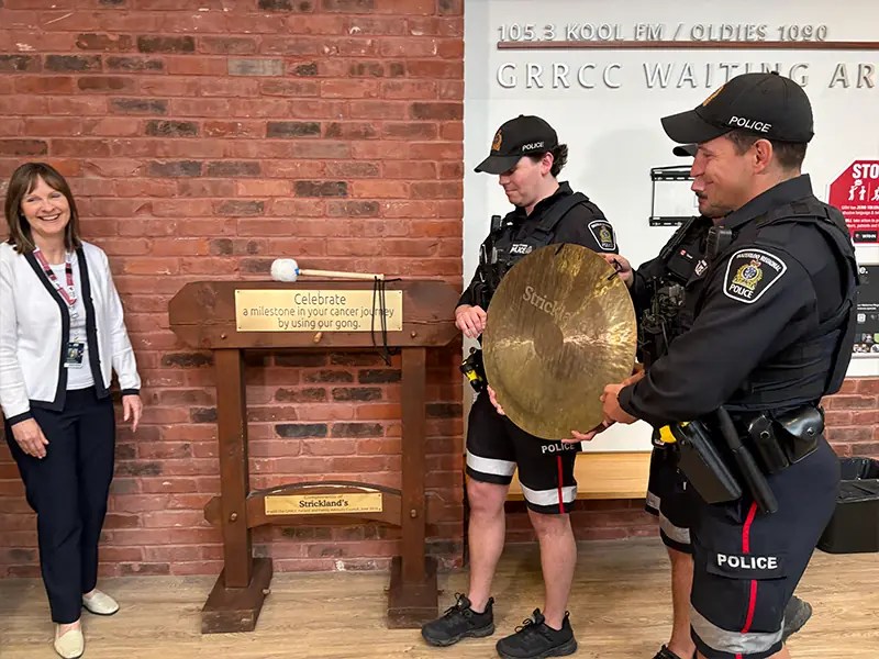 Photo: Local police officers returning the gong to the WRHN @ Midtown Cancer Centre
