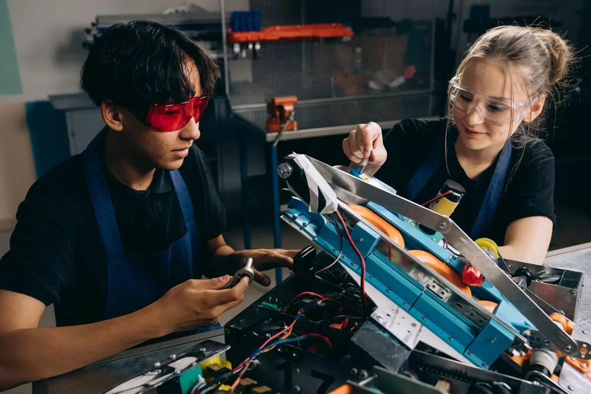 Students building and wiring a robotics/drone kit together in a classroom workshop