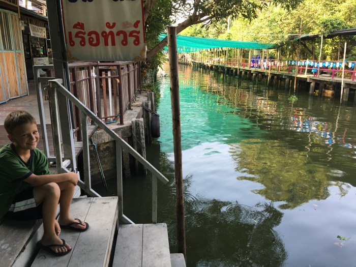 Evan enjoys a quiet moment beside the canal before the floating market opens