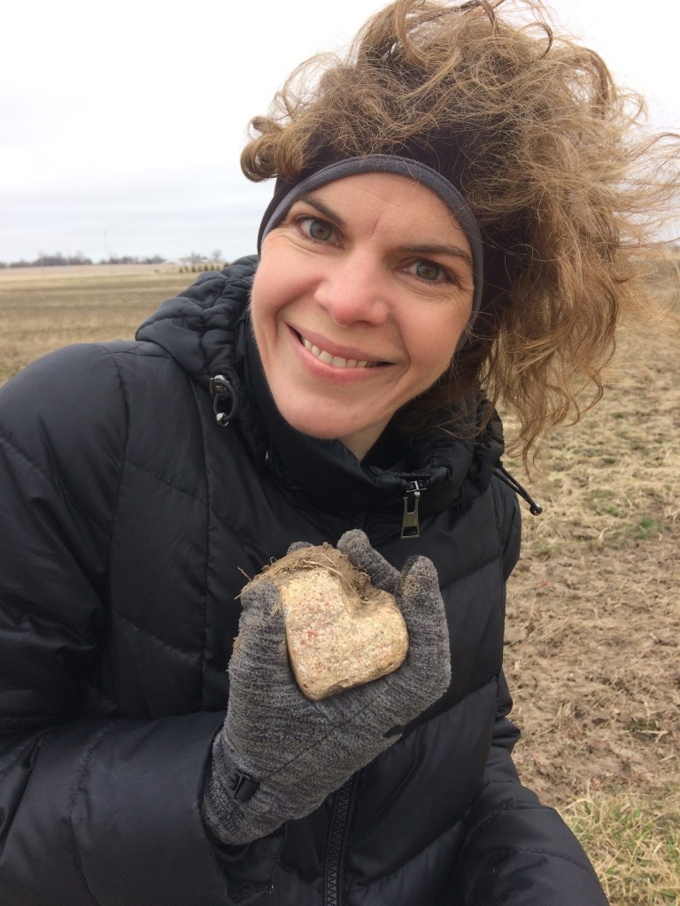 Woman smiling holding sufficient grace heart-shaped rock