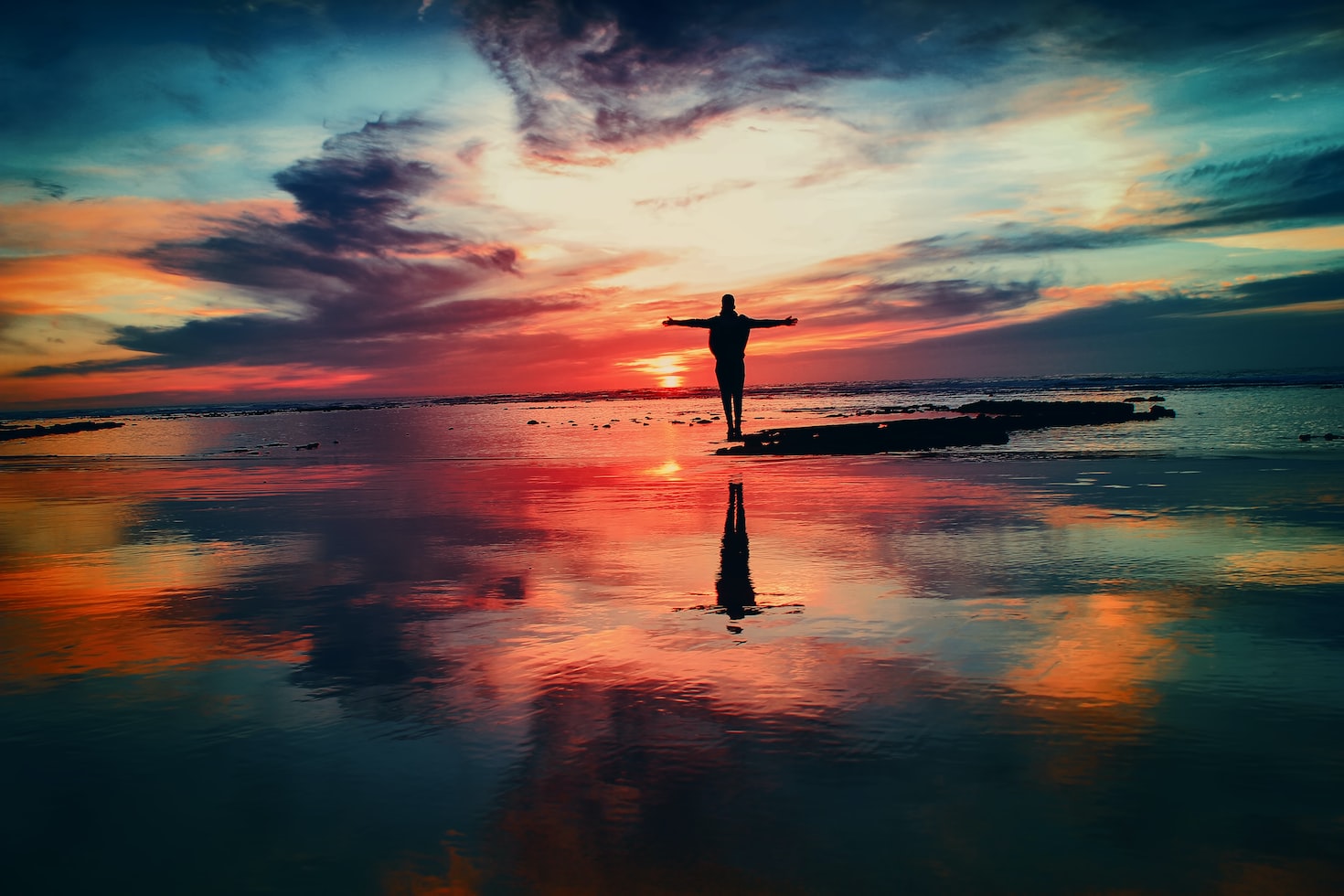 person standing on the beach at sunrise