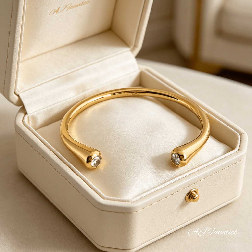 Polished gold stainless steel Fusion Spark open cuff bangle bracelet with petite cubic zirconia stones at tapered ends displayed in a jewellery box.