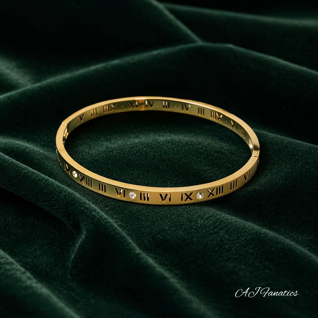 Eterna Roma stainless steel gold bangle bracelet with Roman numerals and crystal accents displayed on deep green velvet.