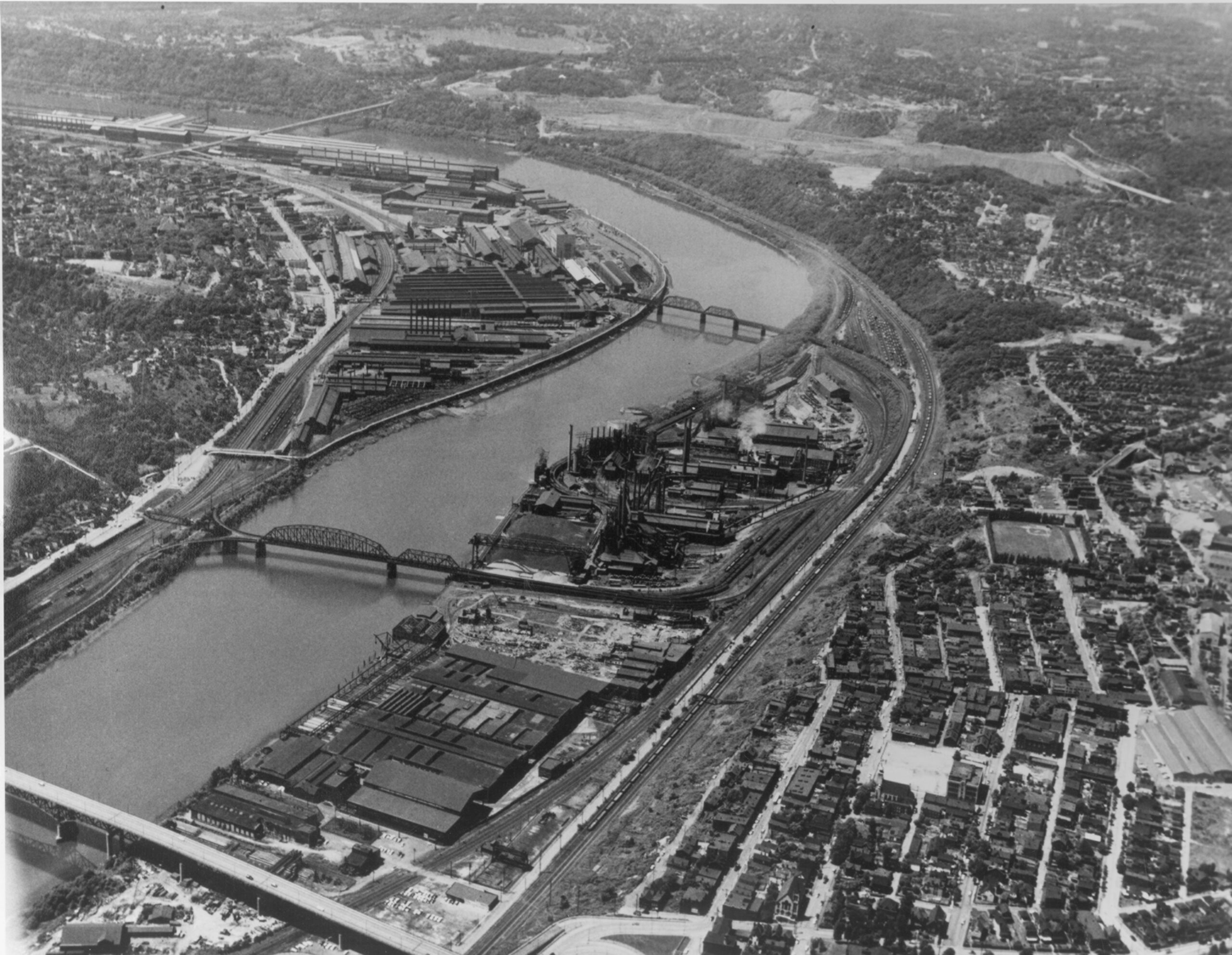 A black and white photo of factories along a river