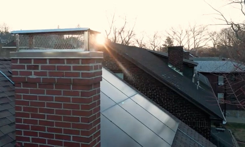 Solar panes on a roof, with part of a chimney visible.