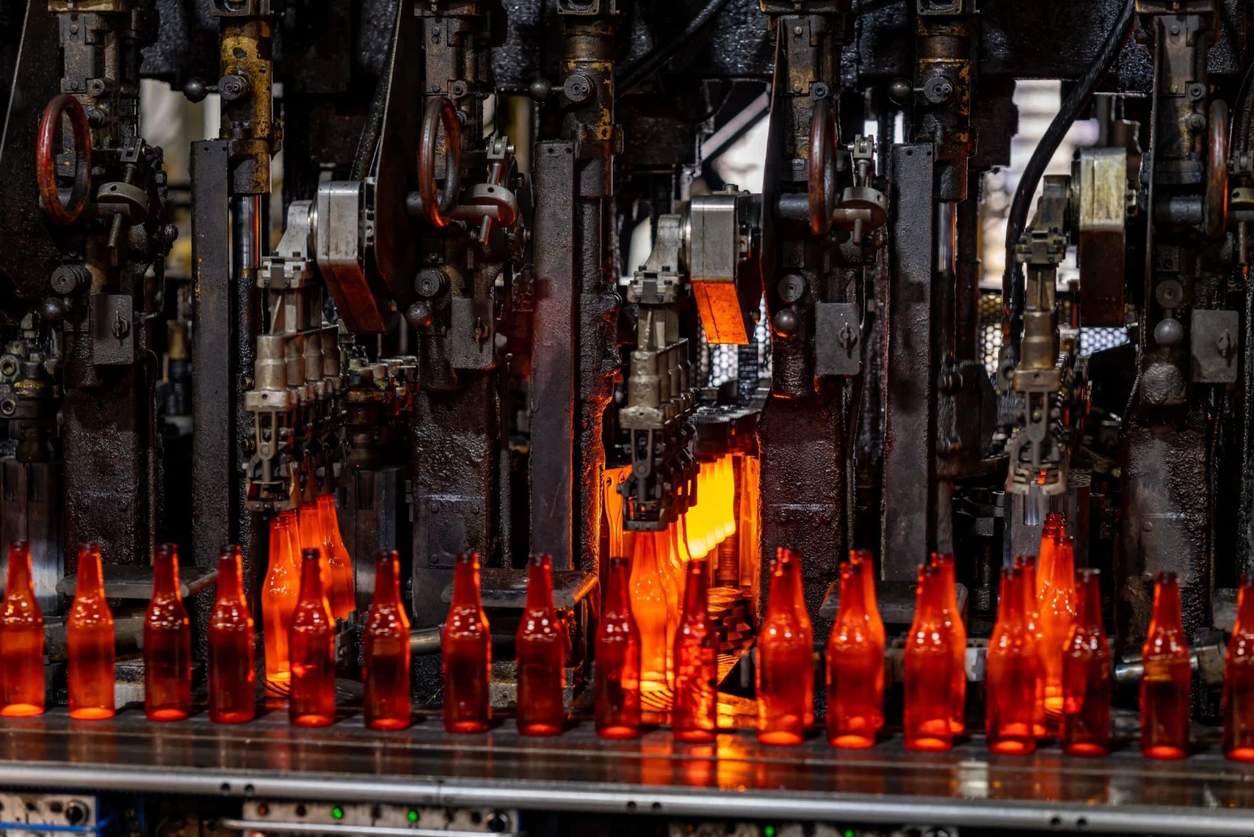 Amber-colored glass bottles on a conveyor belt.