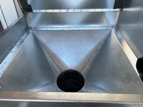 A large sliver tank with a hole at the botton.