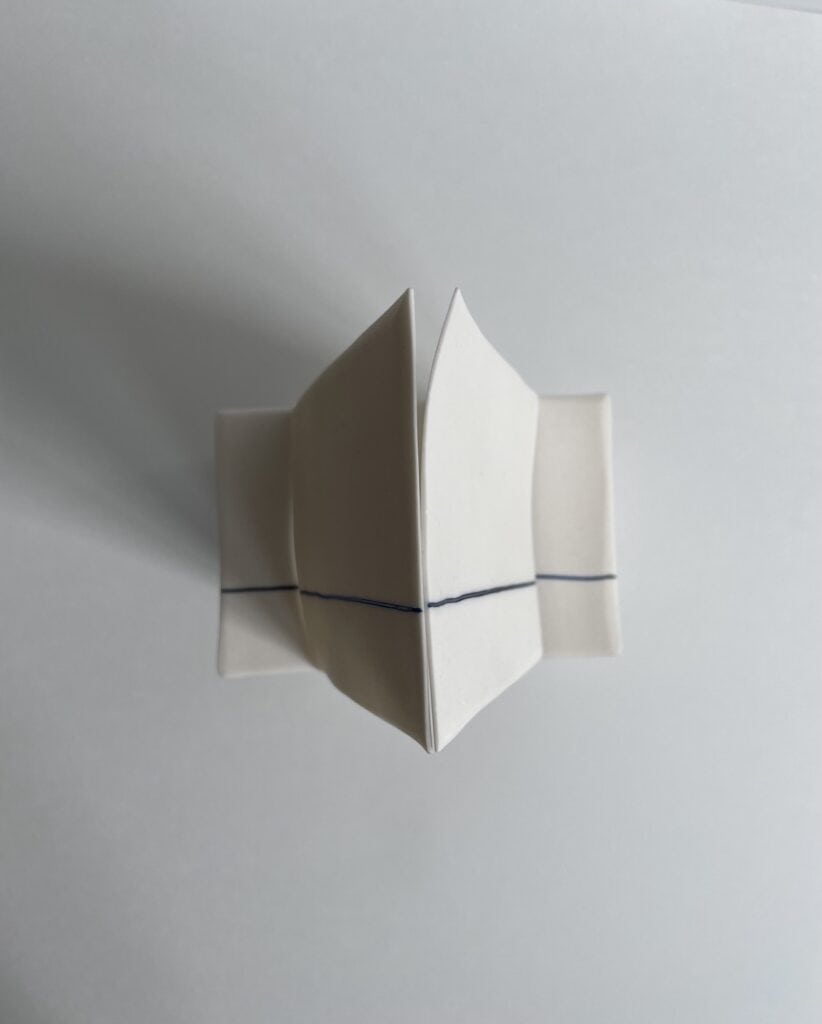 Top view of white porcelain 'cards', with a blue lined on their surface, that lines up.