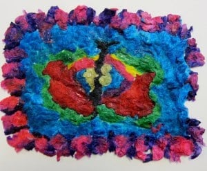 Colorful abstract art piece with layered, textured patches in blue, red, pink, green, and yellow on a white background.