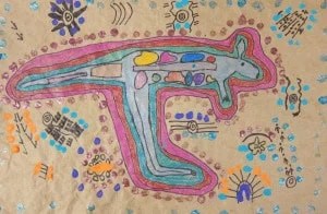 Colorful abstract drawing on brown paper featuring a kangaroo-like shape with various symbols and patterns around it, inspired by Australian Art.