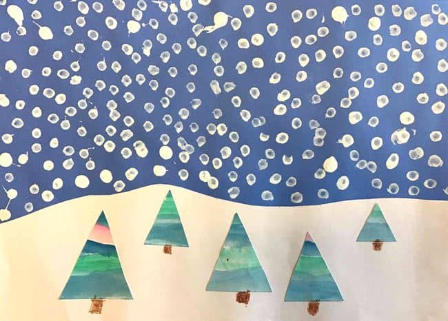 A winter scene featuring painted trees on snowy ground with white dots representing snowflakes against a blue sky, capturing the beauty of landscape art.