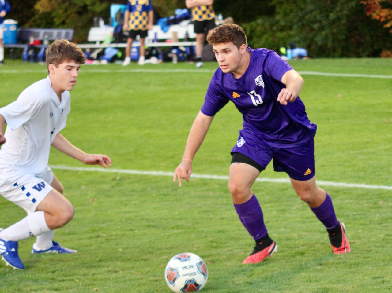 Soccer player dribbles past a defender