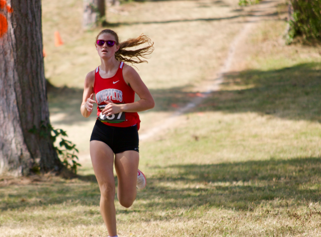 A cross country runner heads toward the finish line