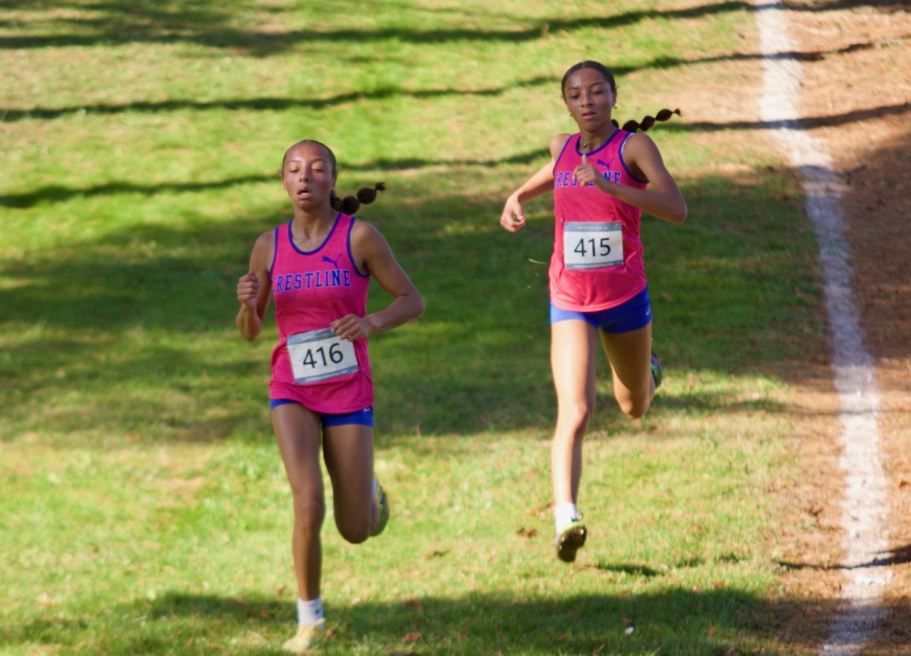 cross country runners sprint toward the finish line