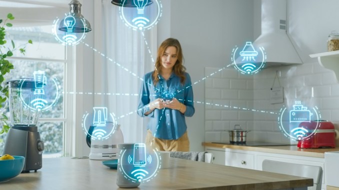 Internet of Things Concept: Young Woman Using Smartphone in Kitchen. She controls her Kitchen Appliances with IOT. Graphics Showing Digitalization Visualization of Connected Home Electronics Devices “स्मार्ट होम सुरक्षा प्रणाली का डैशबोर्ड”