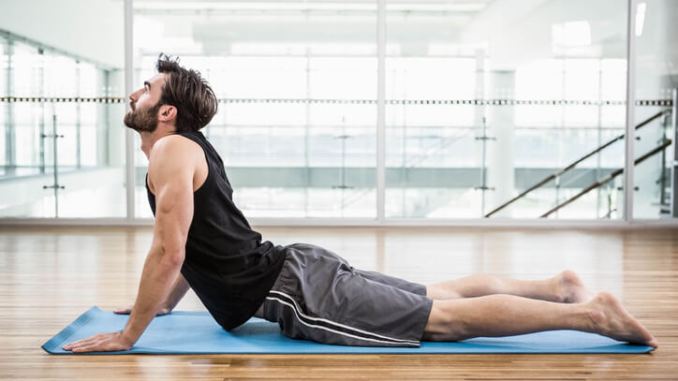 Stretching Exercises for Back Pain “नी-टू-चेस्ट स्ट्रेच करते हुए व्यक्ति”