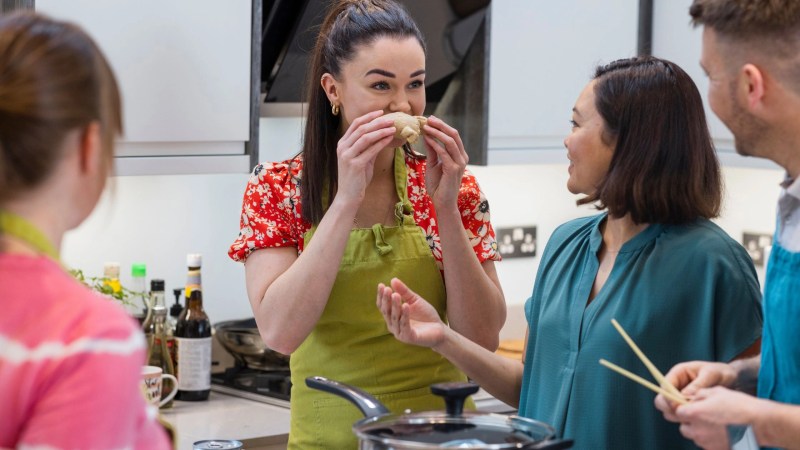 Students enthusiastically learn to cook local dishes from an expert chef in Bali. This photo captures a top Bali cooking class, where participants learn from an expert chef. It highlights a hands-on, engaging culinary experience.