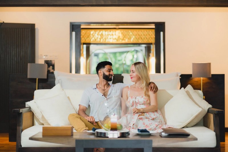 A couple enjoys a stunning sunset ocean view from a cliffside in Uluwatu, embodying a luxurious and dramatic honeymoon in the hotel.