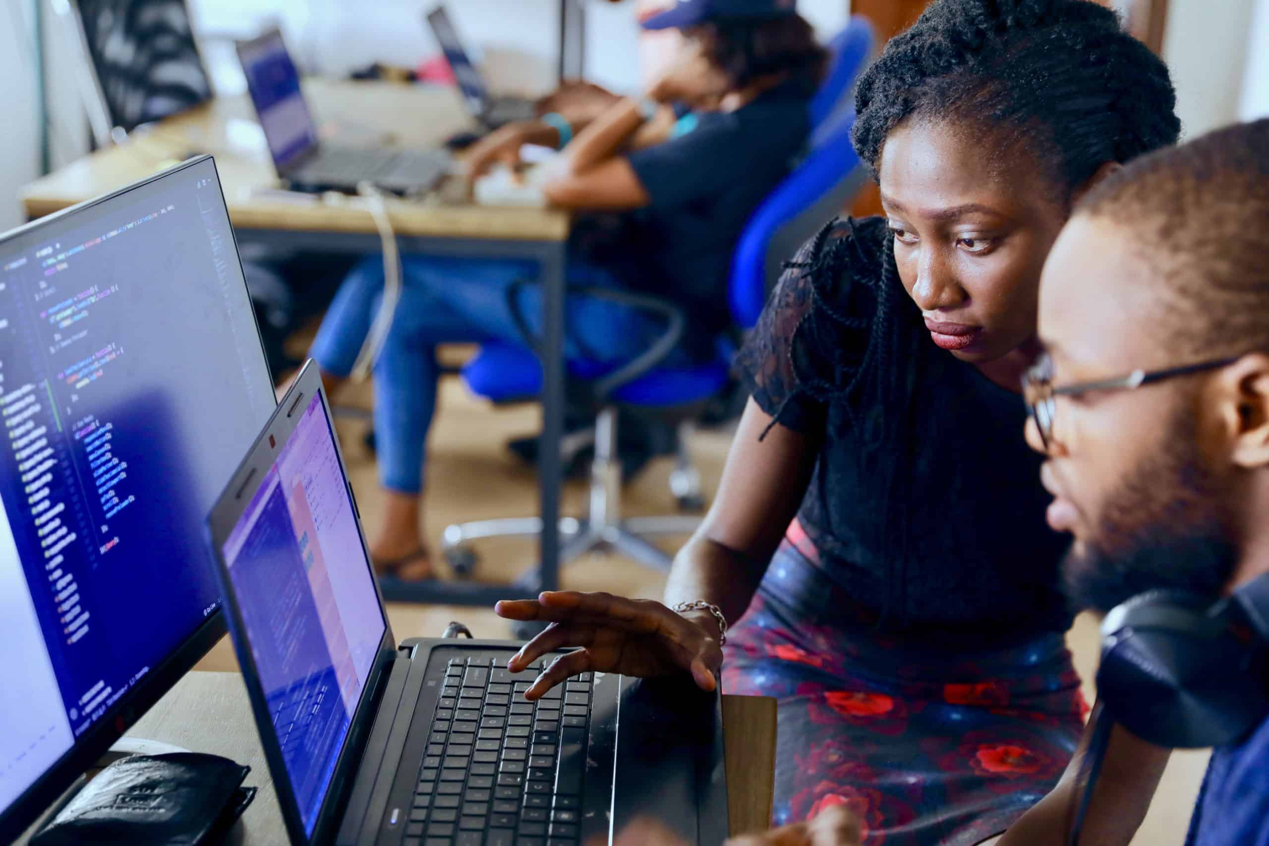 an instructor and a student looking at a computer screen.