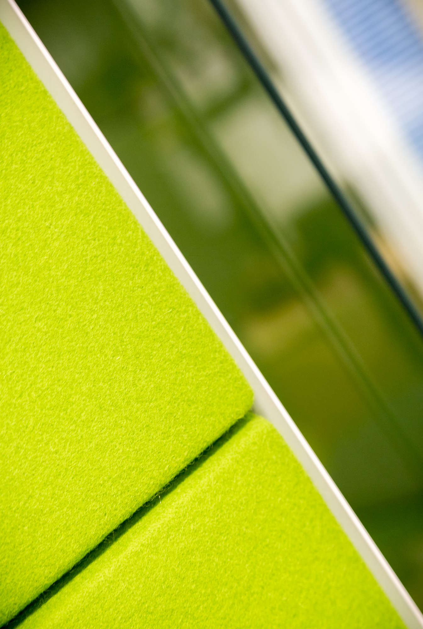 Green felt cushion back in front of a out-of-focus glass window