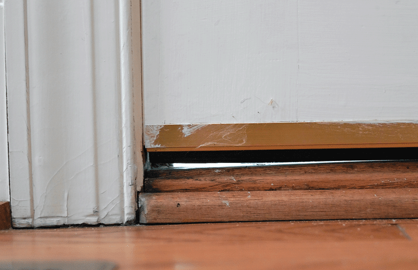 Drafty door due to a gap between the door and door sill.