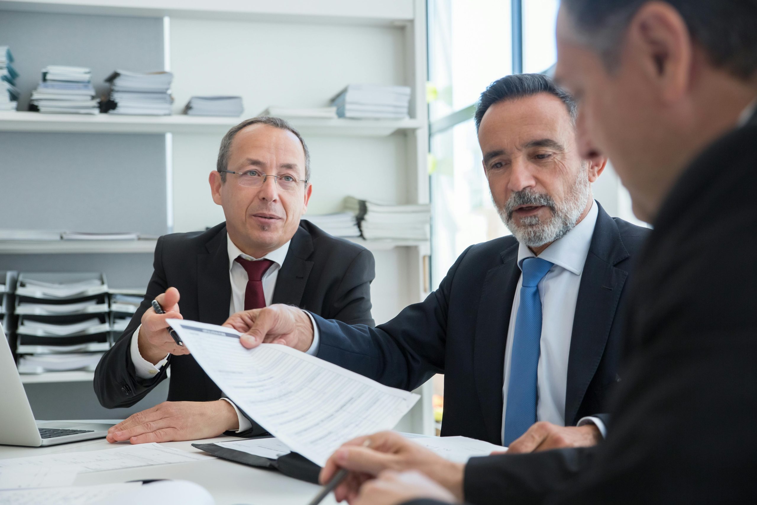 black-suit-having-conversation-at-work-discussing top 5 reasons to acquire an LLM.