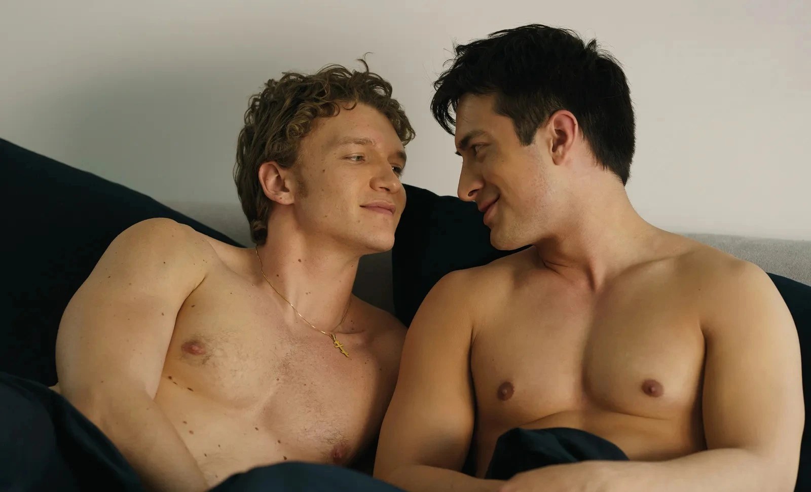 Close-up of Shane Hollander and Ilya Rozanov sharing a quiet, intimate moment in bed from the Heated Rivalry series adaptation.