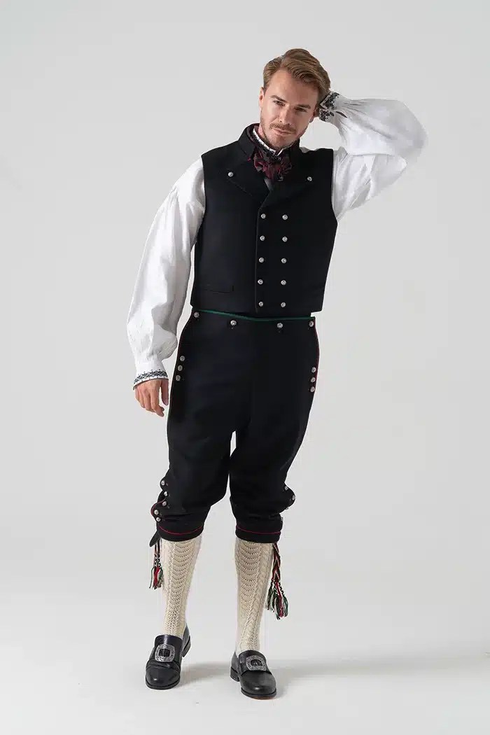 Mann uten jakke og hatt i Øst Telemark bunad, fremhever vestens detaljer og tradisjonelle mønster.