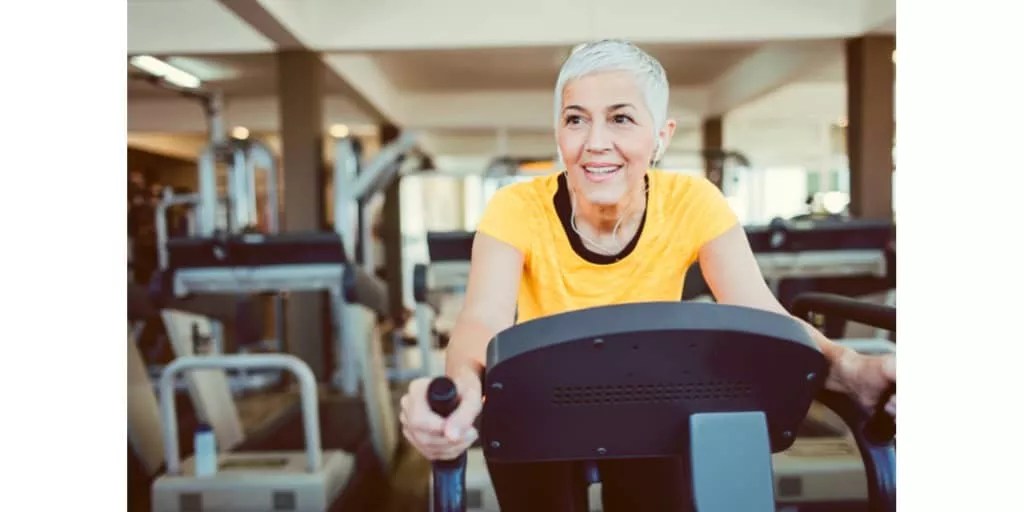 Mature woman with flat feet exercising on a treadmill in a gym