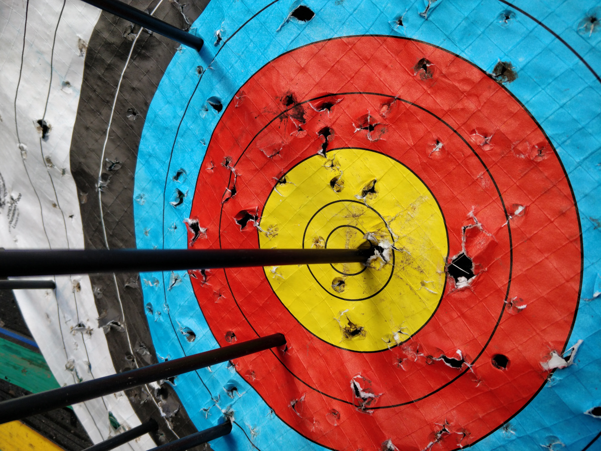 Archery target with arrows and one arrow in the bullseye