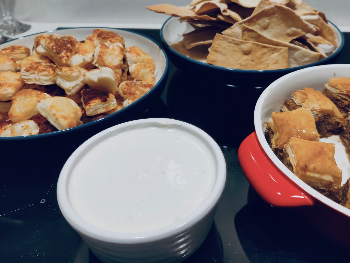 An array of bowls containing beige food for a buffet, and a bowl of fresh home made whipped feta dip