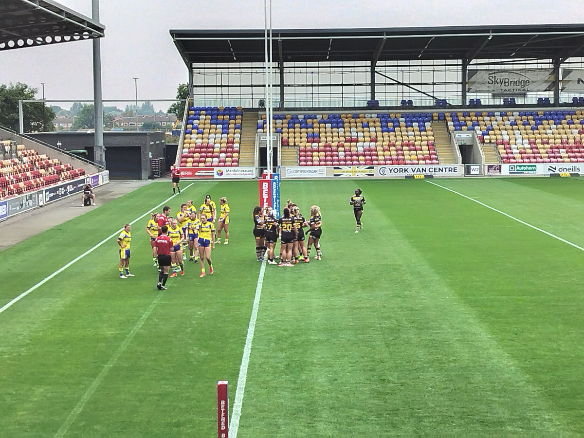 Rugby players from two teams in the goal area after a try has been scored. Something you might see when Watching Rugby League Live For The First Time