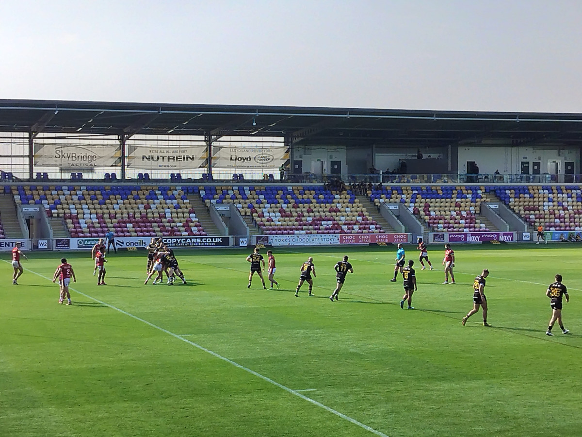 Watching Rugby League Live For The First Time and seeing the teams playing on a green pitch in a small stadium on a sunny day
